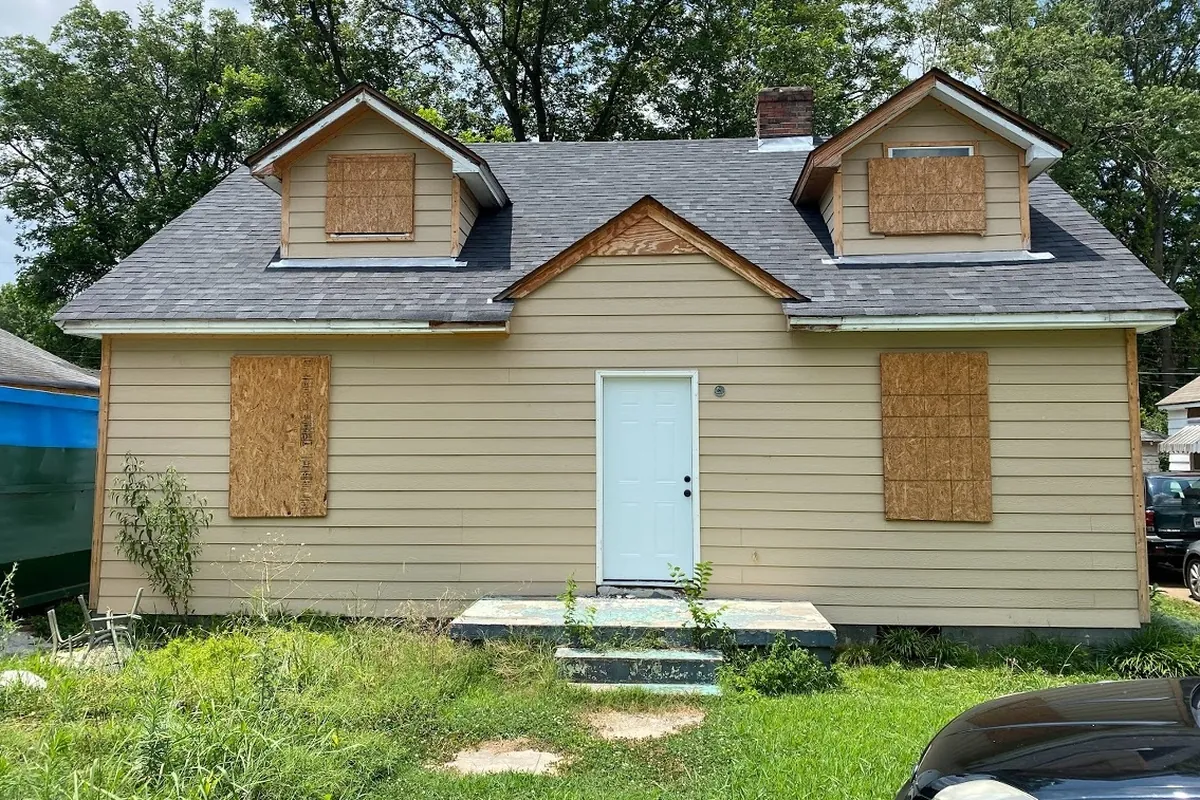 Front before renovation, Boarded-up cape, brought back